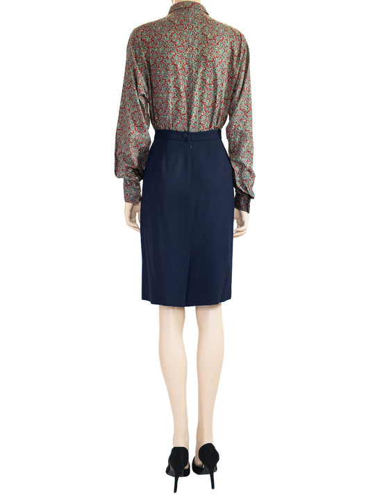 This is a back view of the model wearing a Chaus vintage dark blue wool skirt as part of a two-piece 1980s suit. 